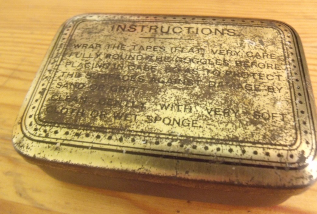 ww1 goggle tin - Reads: Instructions Wrap the tapes (flat) very carefully round the goggles before placing in case so as to protect the surfaces against damage by sand or grit. Clean gently with very soft cloth or wet sponge. 